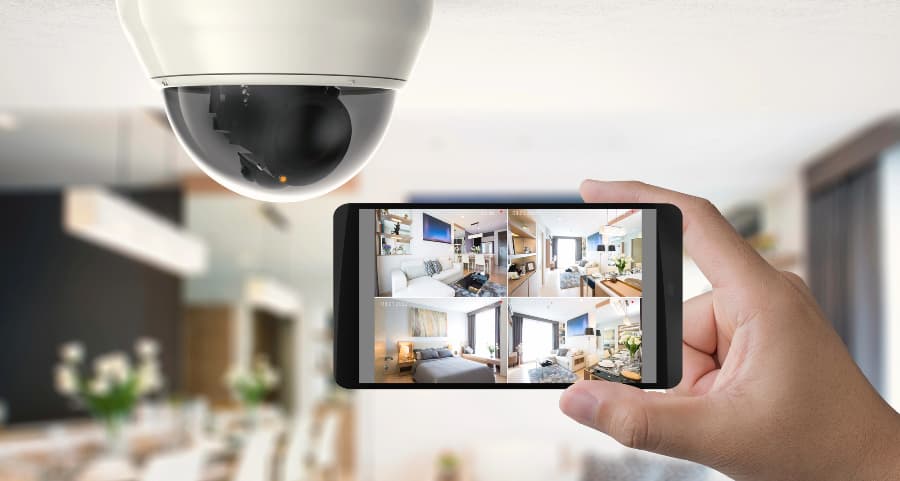 Homeowner holding smartphone with video feed from security cameras in San Jose